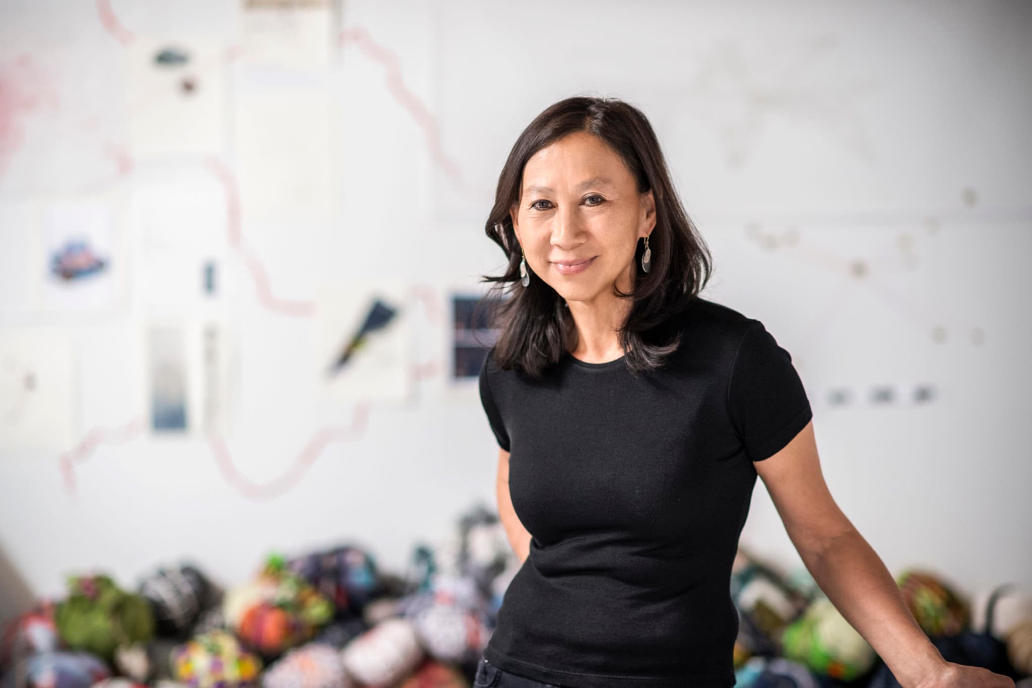 A portrait of Yu-Wen Wu, posed in front of colorful works.