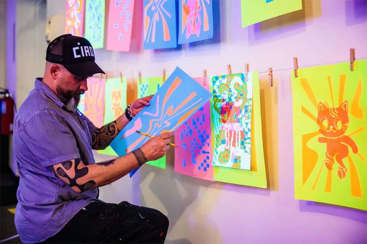 A man inspects his screen printing.